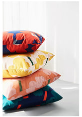 Stack of colorful pillows on a white surface