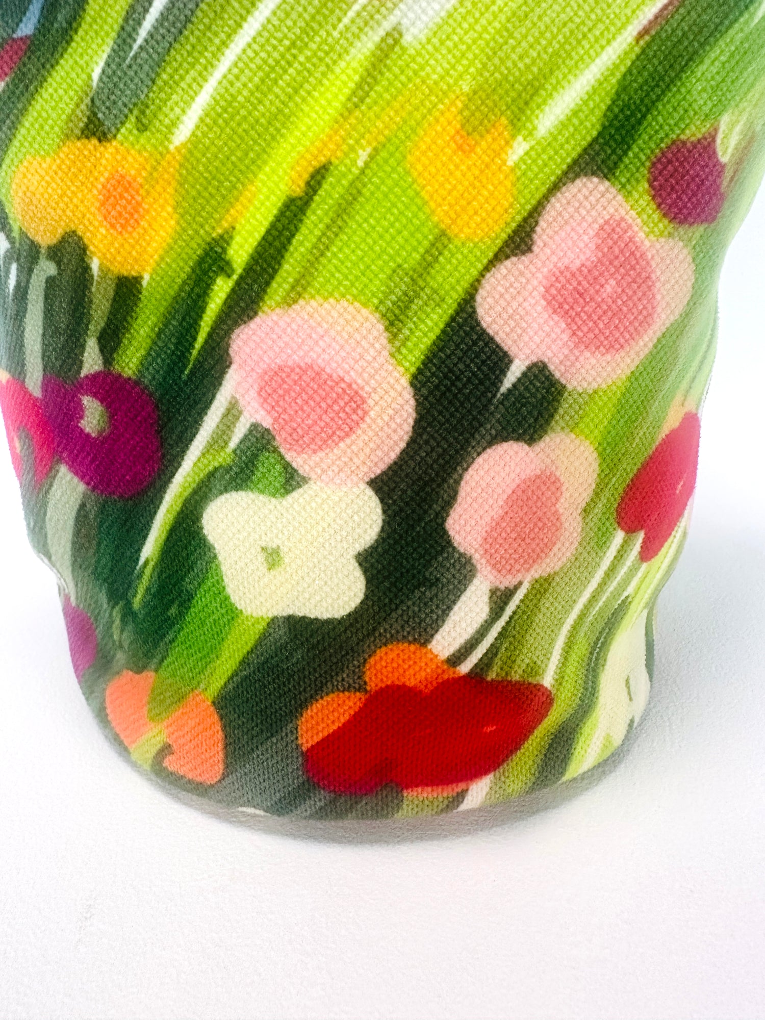 Close-up of a colorful floral-patterned fabric with red, pink, yellow, and green flowers.