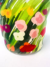 Close-up of a colorful floral-patterned fabric with red, pink, yellow, and green flowers.